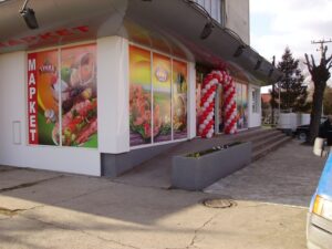 Spoljašnji prikaz prodavnice Trlić u Ubu sa rampom za invalide. Glavni ulaz. Povoljna kupovina. Loklacije prodavnica. Povoljna kupovina sa velikim popustima na proizvode u Trliću.